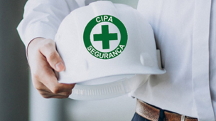 Pessoa segura capacete branco com símbolo da CIPA Segurança, representando prevenção de acidentes e compromisso com a segurança no trabalho.