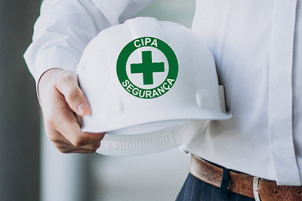 Pessoa segura capacete branco com símbolo da CIPA Segurança, representando prevenção de acidentes e compromisso com a segurança no trabalho.