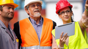 Integrantes da CIPA usam capacetes e coletes de segurança enquanto analisam informações em obra, reforçando prevenção de riscos e segurança no trabalho.