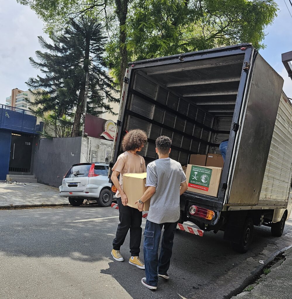 Colaboradores da ConstaMed carregando os caminhões com os suprimentos para a ação humintária internacional.