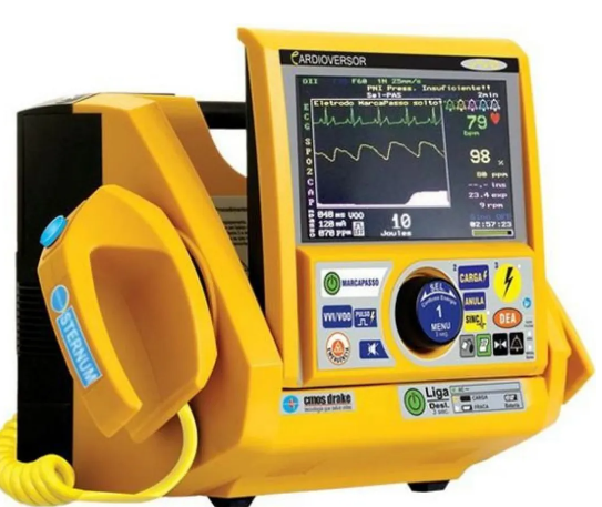Cardioversor desfibrilador amarelo da marca CMOS Drake com monitor integrado exibindo parâmetros cardíacos. Equipamento hospitalar utilizado para desfibrilação, cardioversão e monitoramento em emergências cardíacas.
