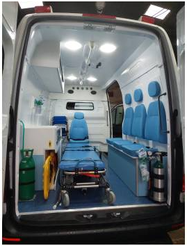 Interior de ambulância de suporte básico com maca, cilindro de oxigênio e equipamentos para atendimento pré-hospitalar. Estrutura preparada para emergências médicas, garantindo segurança e agilidade no transporte de pacientes.