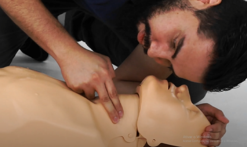 Imagem demonstra ventilação boca a boca durante ressuscitação cardiopulmonar (RCP) em manequim de treinamento. Técnica essencial de primeiros socorros para parada cardiorrespiratória e suporte básico de vida.